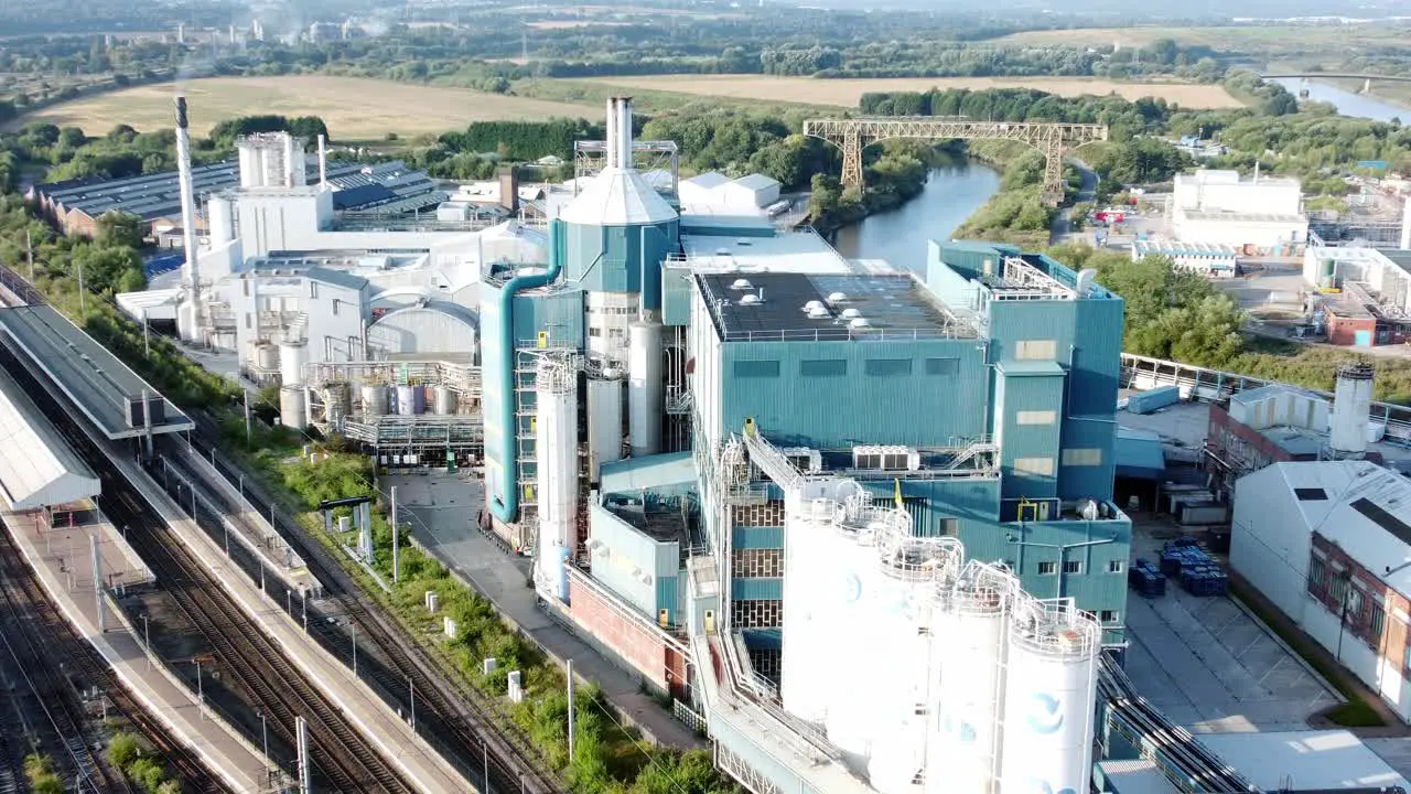 Industrial chemical manufacturing factory next to Warrington Bank Quay train tracks aerial view zoom in