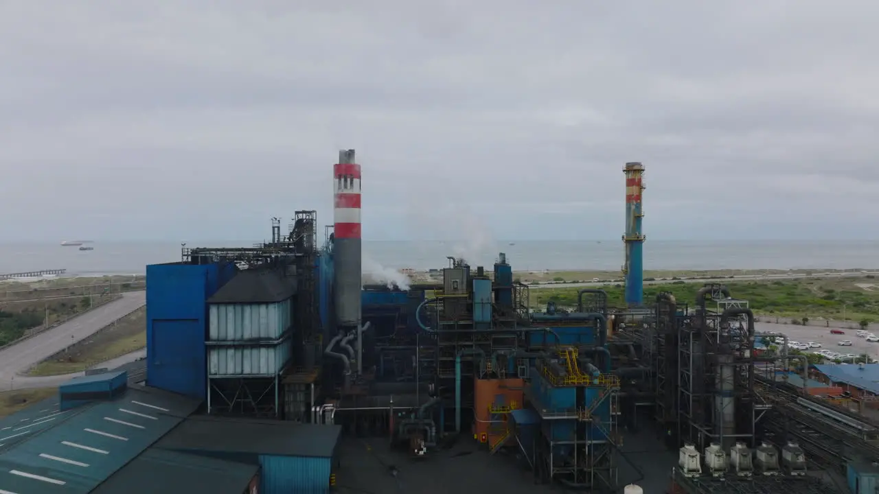 Forwards fly above production plant Piping and chimneys of chemical industry factory near seacoast Port Elisabeth South Africa