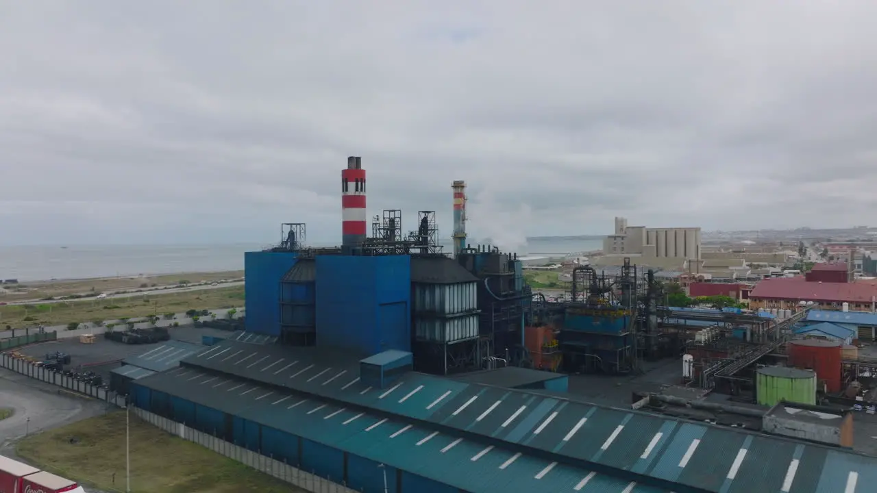 Industrial plant on seaside Slide and pan aerial footage of factory with chimneys Port Elisabeth South Africa