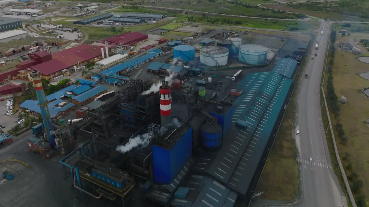 Aerial descending footage of industrial plant Chemical factory with production hall piping and chimneys Port Elisabeth South Africa