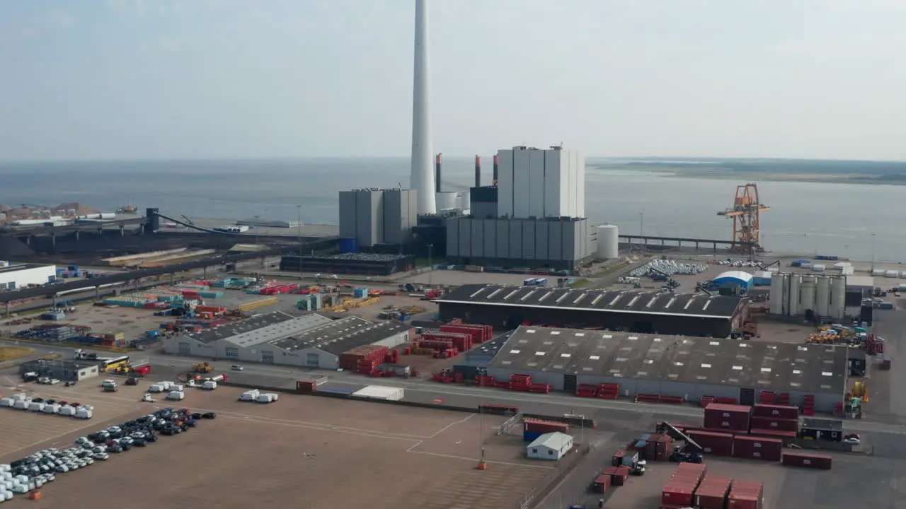 Aerial flight moving toward the Esbjerg Power Station in Denmark Drone view look up revealing the chimney the tallest in scandinavia