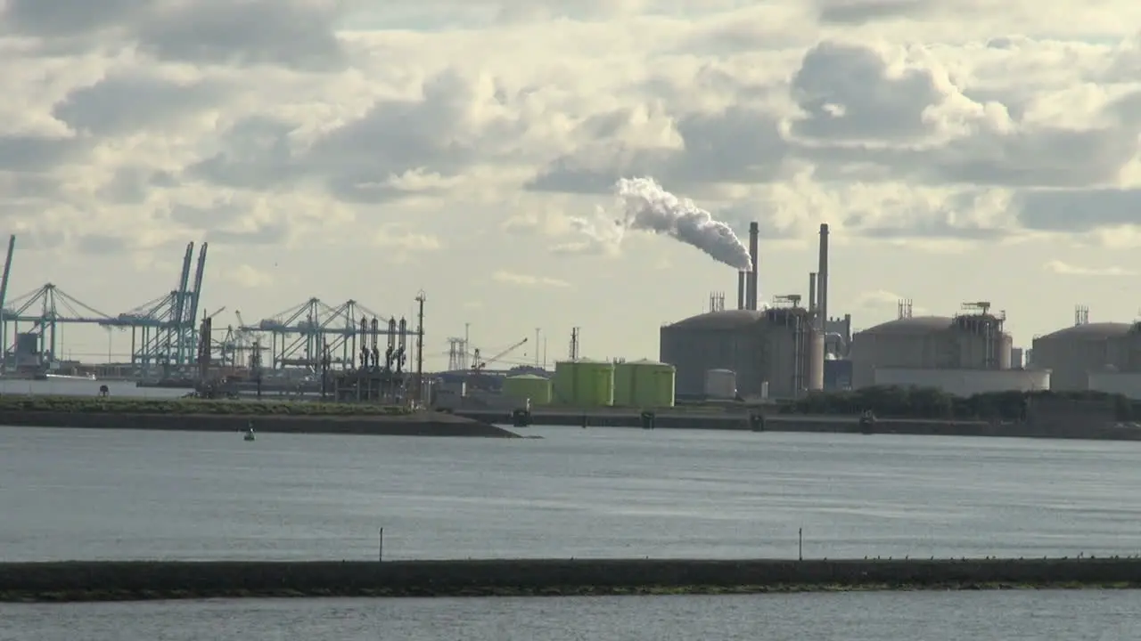 Netherlands Rotterdam refinery smoke rising from cylindrical tanks 12