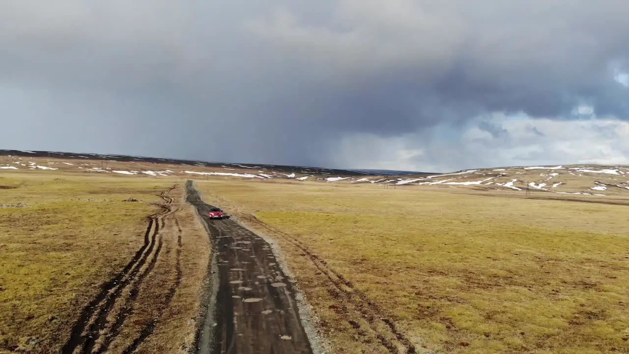 Red Car Driving in a Rural Landscape