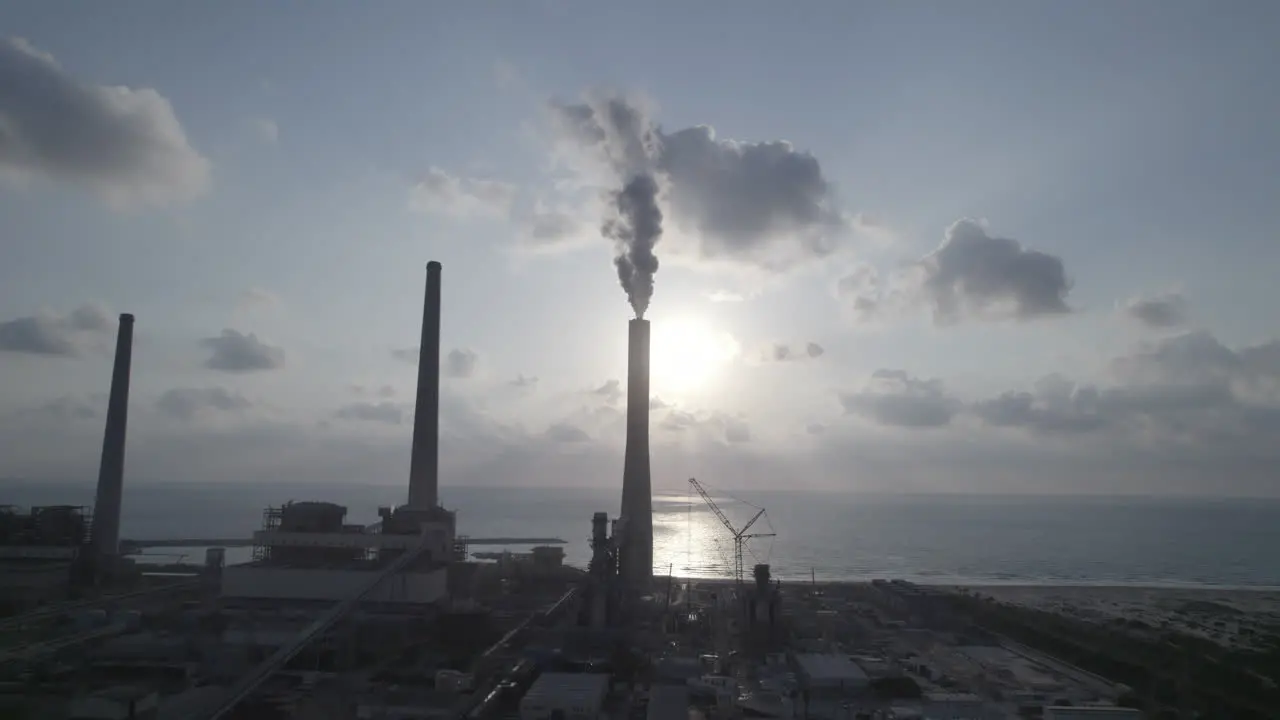 Aerial view of a power plant with 4 chimneys one of which emits thick smoke into the air polluting energy in Israel