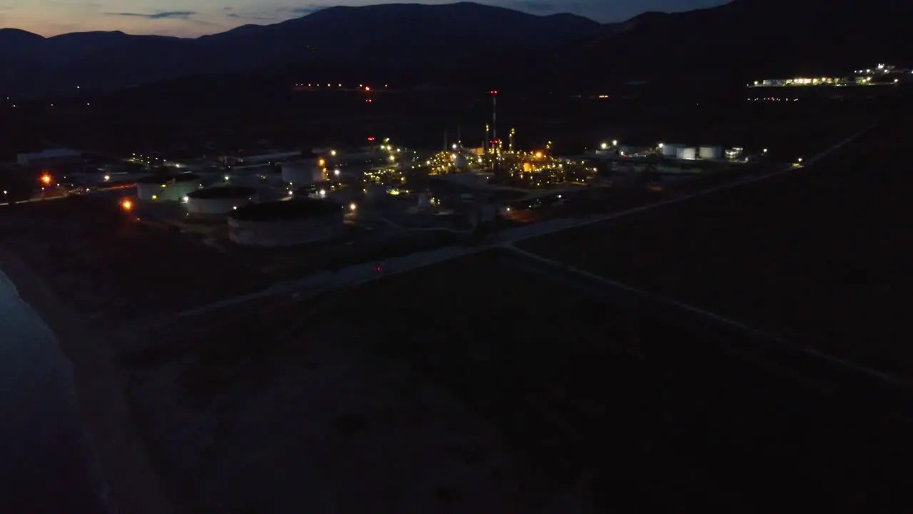 Aerial approaching oil refinery at night environment industry concept