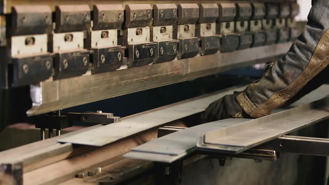 Worker puts a metal workpiece in a machine