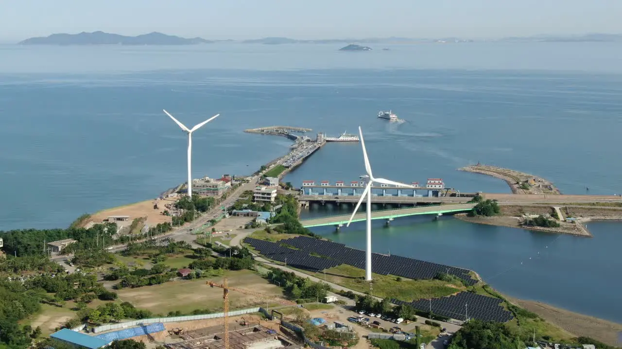 a slowly spinning white wind generator on the sea