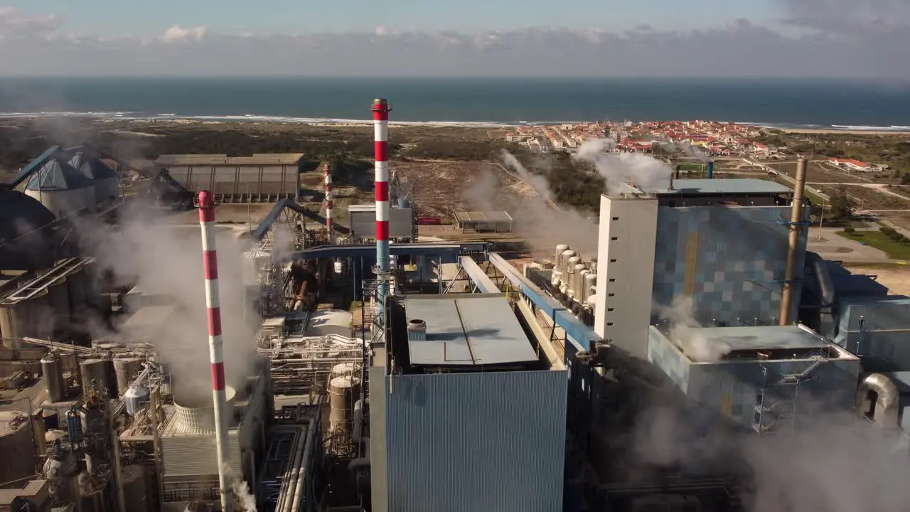 Drone shot of industrial zone with thick smog and burning fossil fuels