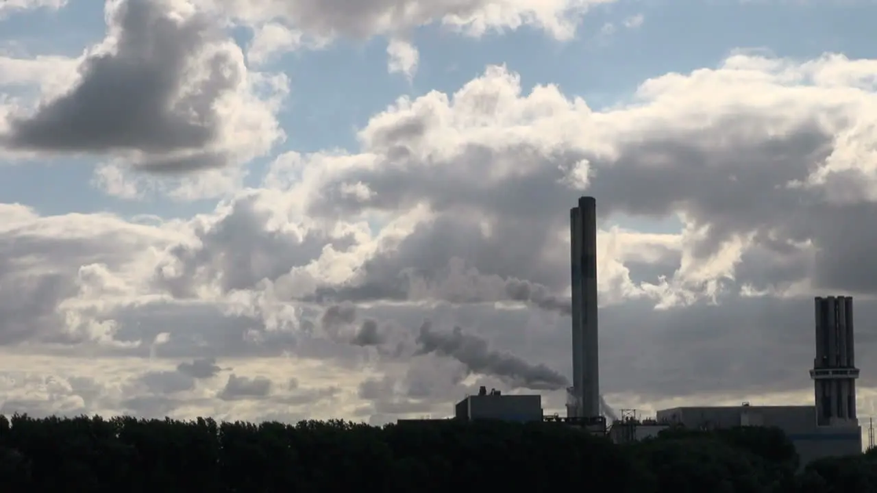 Netherlands Rotterdam two vapor trails from behind smokestacks