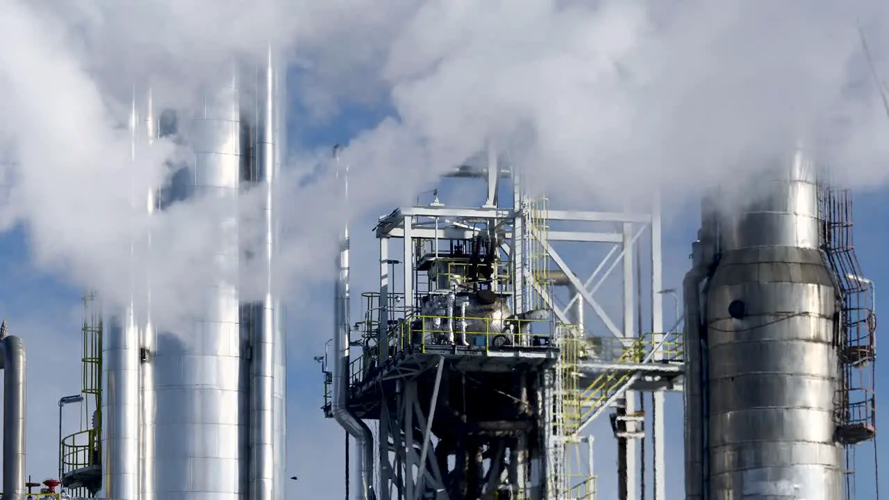 Thick smoke polluting the air is covering the shiny steel installation of the modern chemical plant