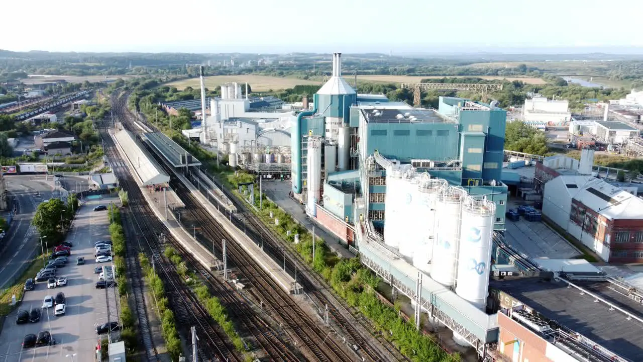 Industrial chemical manufacturing factory next to Warrington Bank Quay train tracks aerial slow descending view