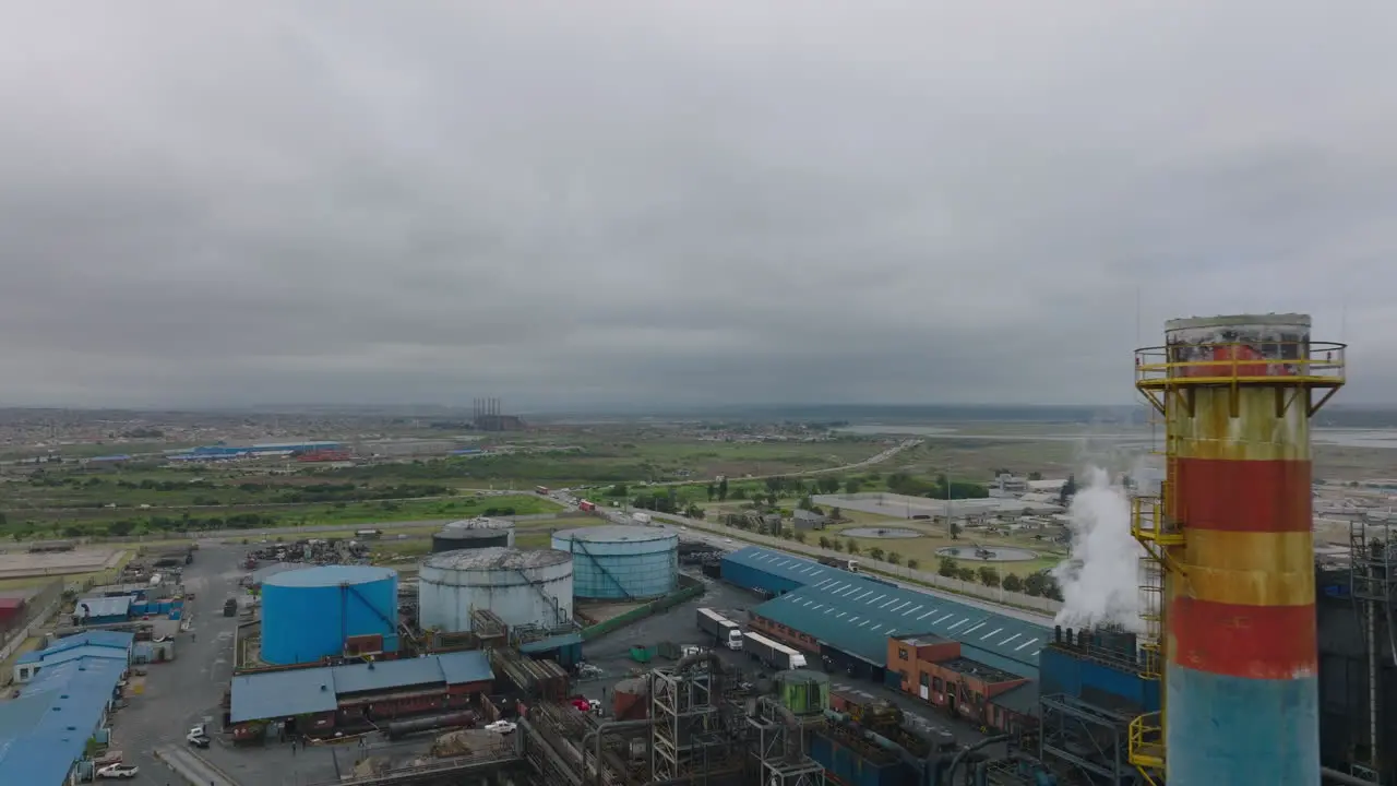 Forwards fly around factory chimney Road leading around industrial site in suburbs Port Elisabeth South Africa