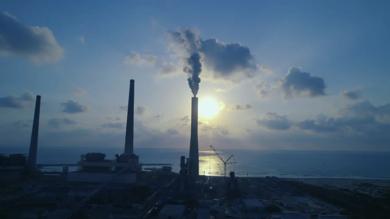 Aerial view of a power plant with 4 chimneys one of which emits thick smoke into the air polluting energy in Israel-1