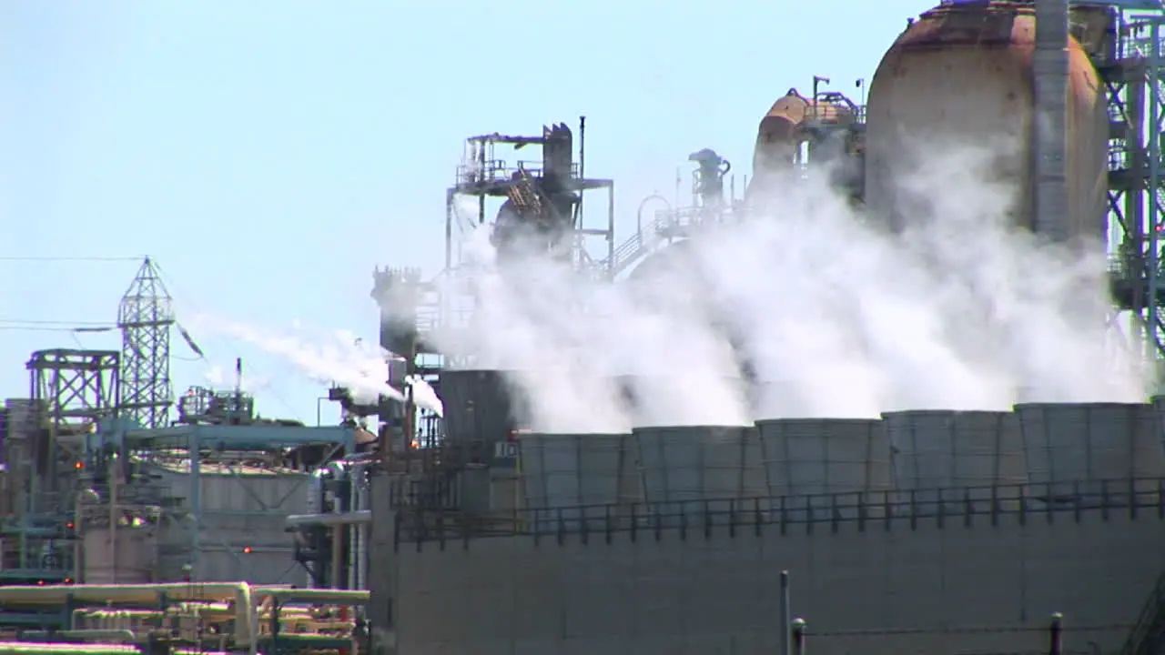 Steam rises from evaporative stacks at a power facility