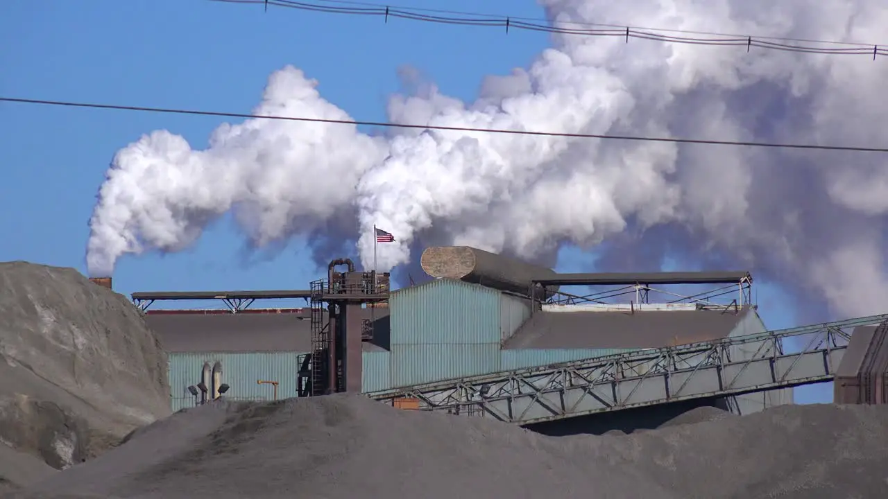 Global warming is suggested by shots of a steel mill belching smoke into the air 1