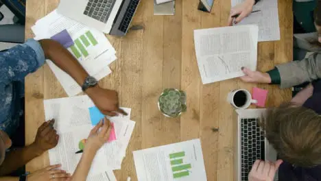 Overhead View Of Male And Female Colleagues Working Together At Desk