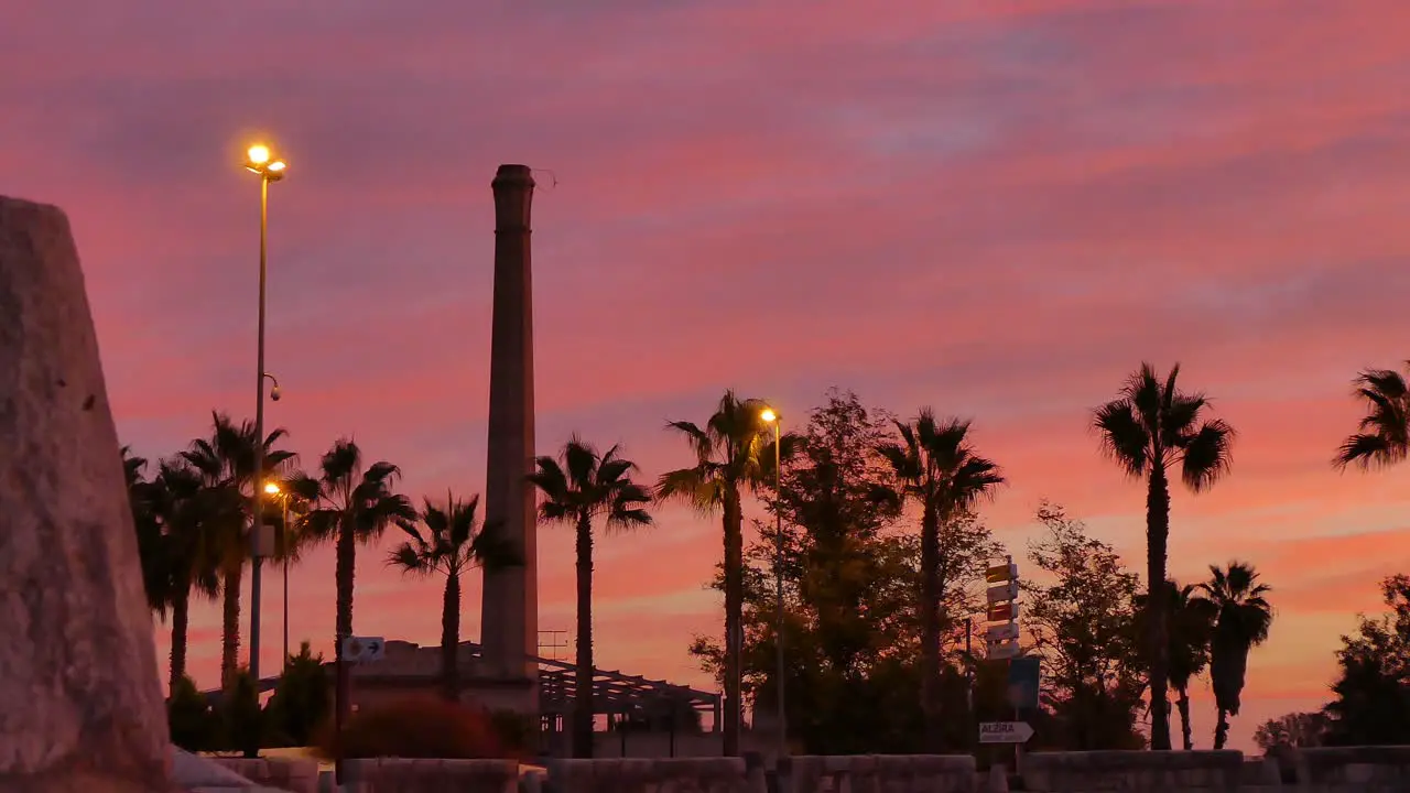 Lovely time lapse of a sunrise with passing cars and in the background the tower of an old factory