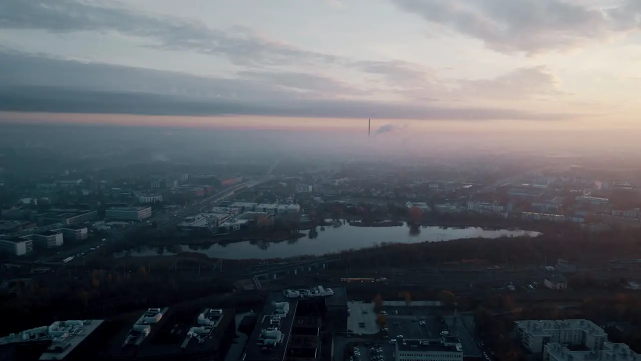 Aerial view of foggy sunrise over industrial district and industrial chimneys