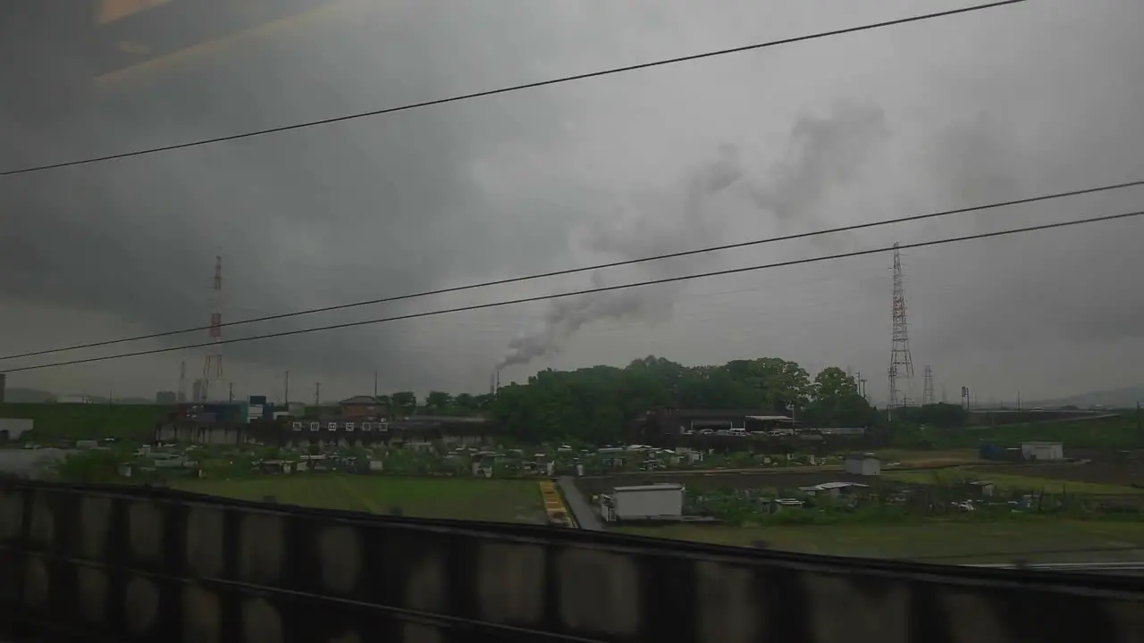 View of industrial area through train window on cloudy day slow motion Japan