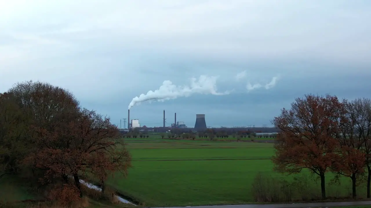 Power plant dramatically appears behind the trees dolly shot with drone