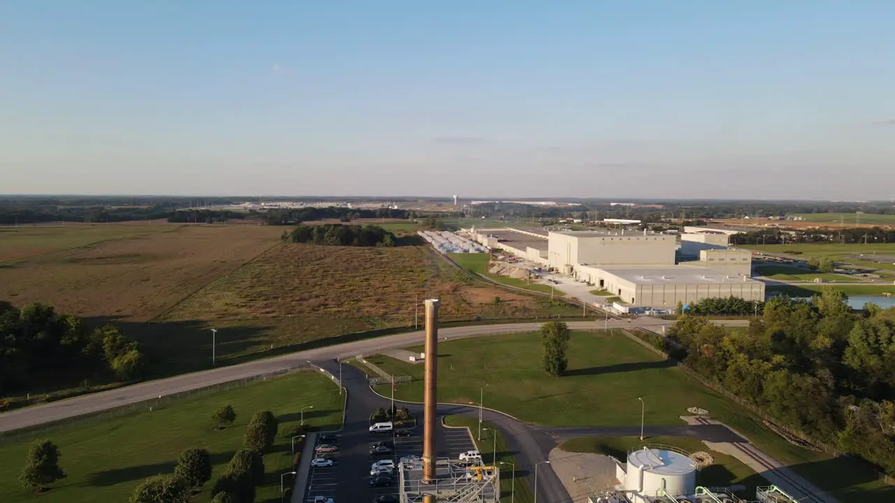 Drone rotating over a smokestack factory fuming by the chimney into the atmosphere in an industrial environment of USA