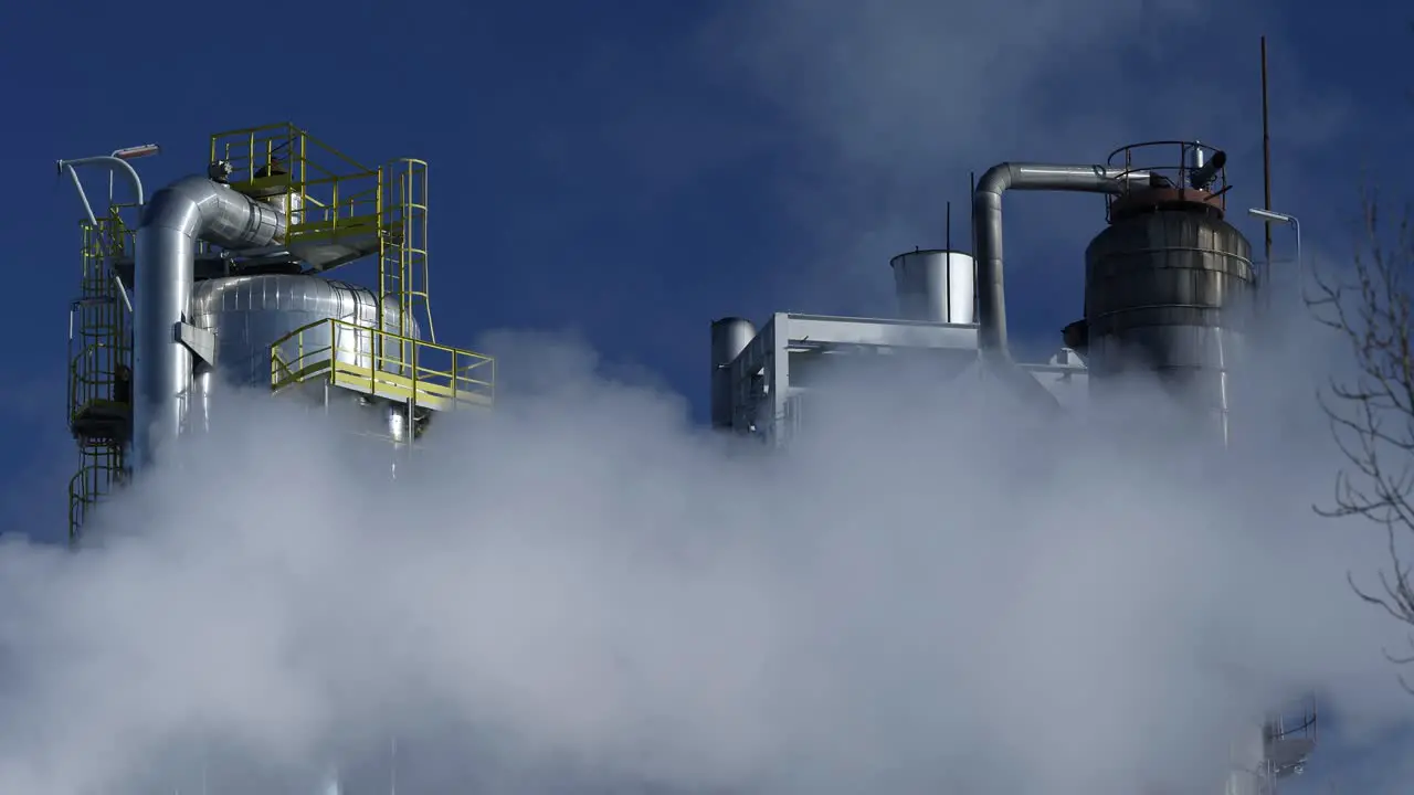 Refinery tower against the blue sky with thick smoke polluting the air