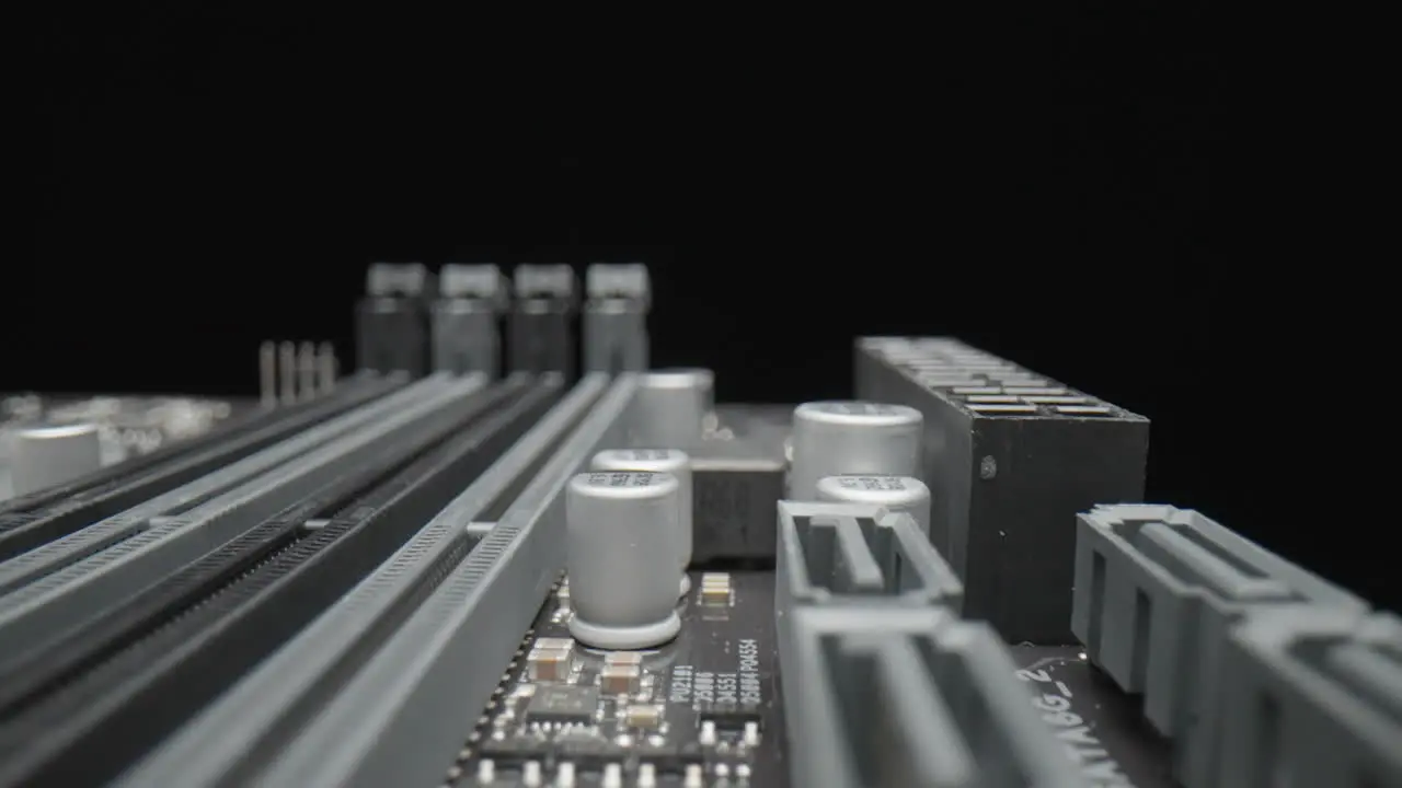 Close-up macro shot of a motherboard on a black background with capacitors and transistors