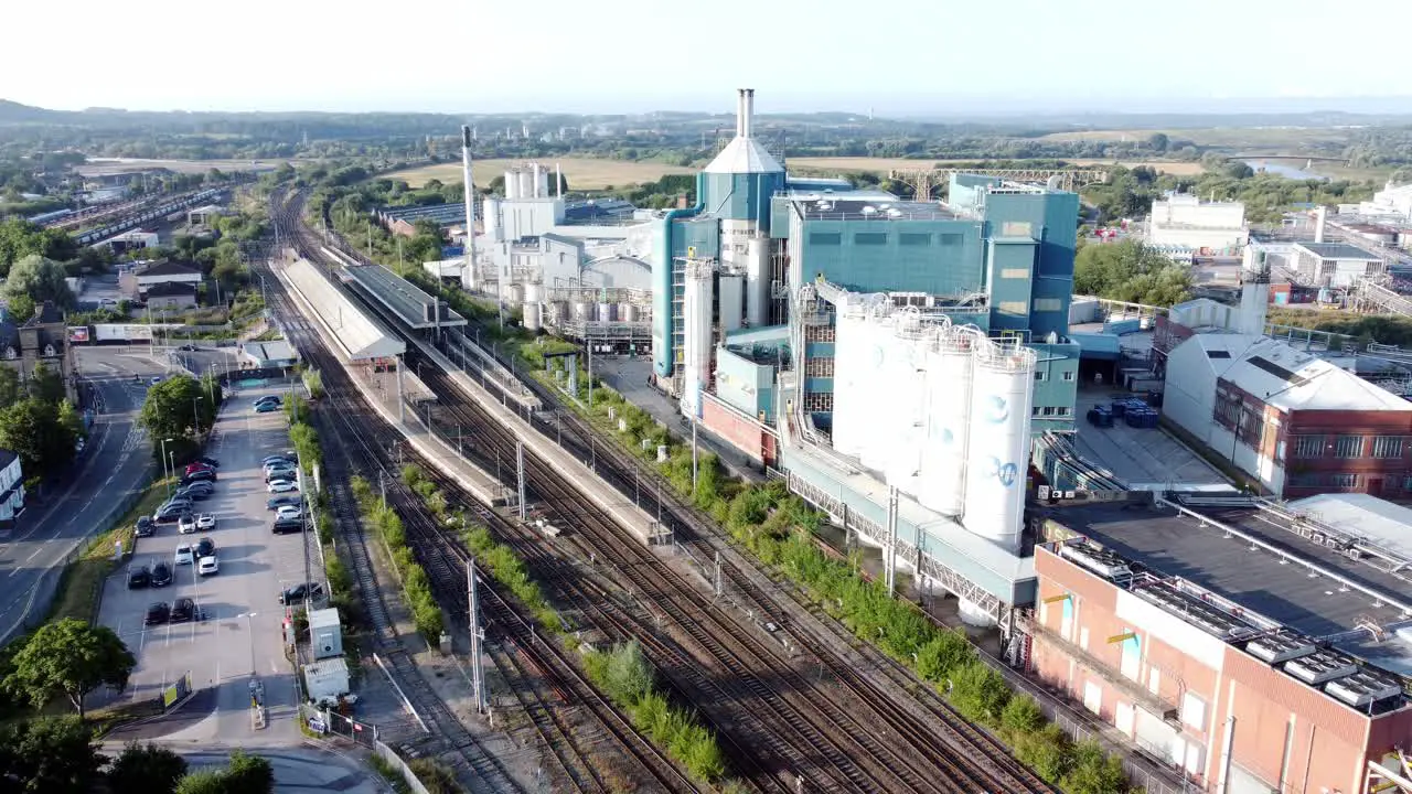 Industrial chemical manufacturing factory next to Warrington Bank Quay train tracks aerial view reversing slowly