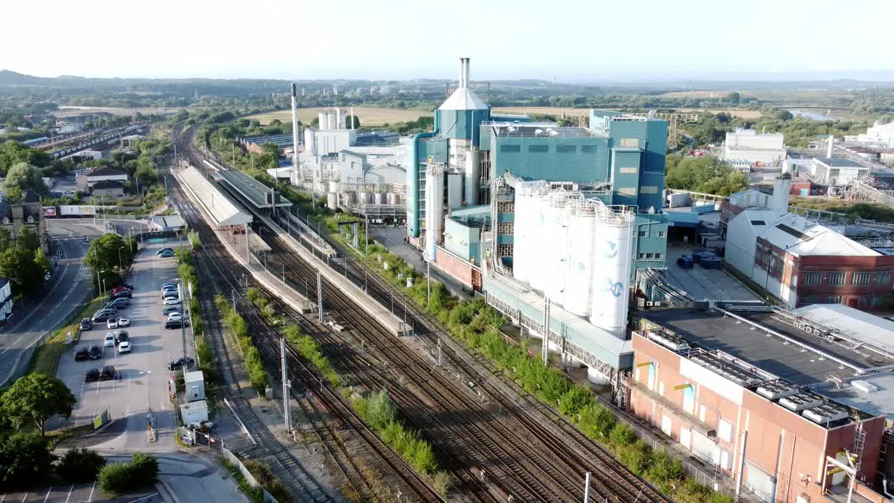 Industrial chemical manufacturing factory next to Warrington Bank Quay train tracks aerial view lowering slowly