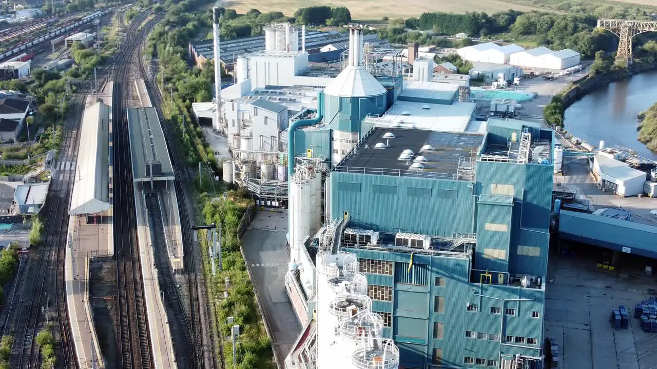 Industrial chemical manufacturing factory next to Warrington Bank Quay train tracks aerial birdseye left orbit view