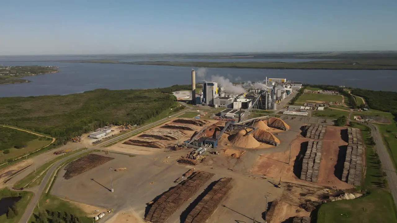 Paper mill factory with smoky chimneys in front of Uruguay River at Fray Bentos