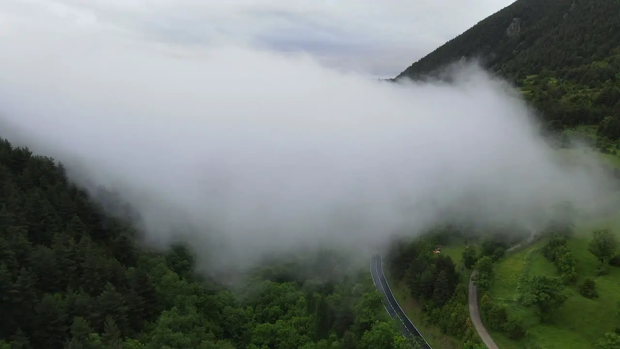 Shot From The Air Coming Out Of A Large Cloud Located Over A Forest In The Pyrenees