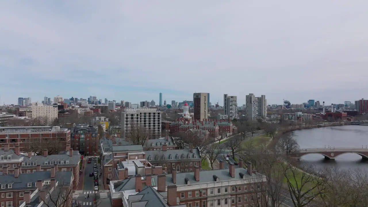 Forwards fly above red brick buildings in Harvard University campus at Charles river waterfront Boston USA