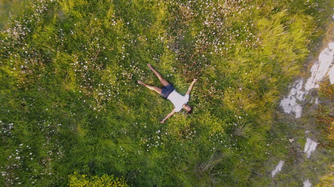 Zoom Out Of A Man Lying And Relaxing On The Edge Of A Cliff Of A Rocky Coastline