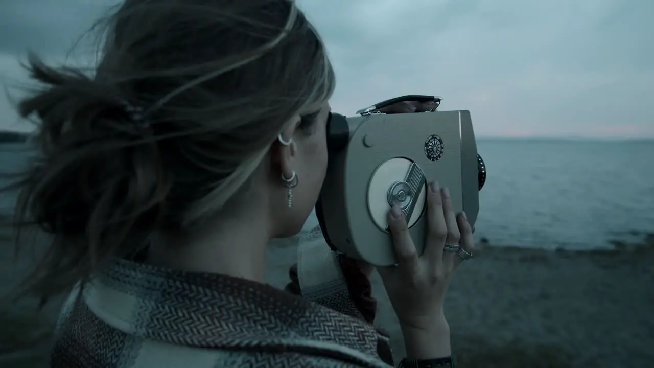 Woman Filming Video with Vintage Camera on Lakeshore