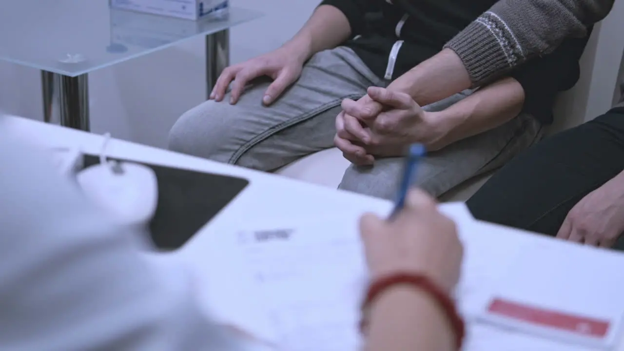 Doctor writing treatment Gay couple waiting for hiv test results