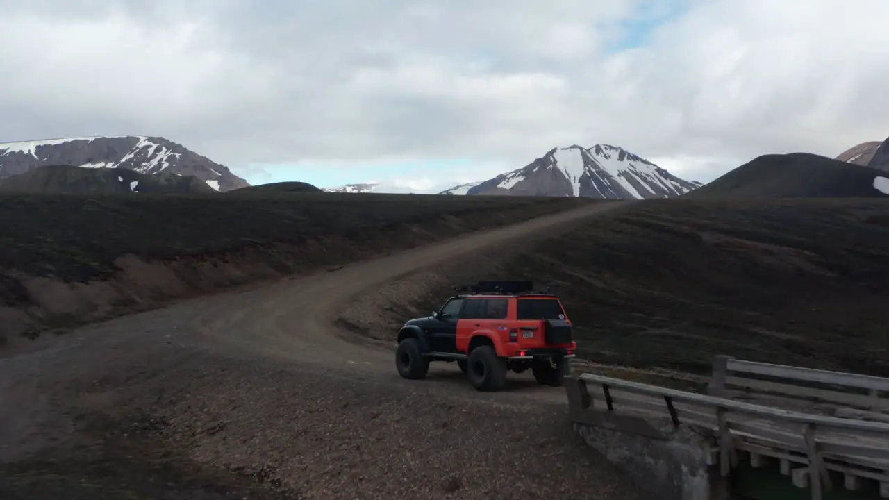 Drone view jeep car parked on dirt road in Iceland countryside Expedition and adventure Aerial view of a offroad vehicle stopped on a trail in icelandic highlands ready to discover wilderness