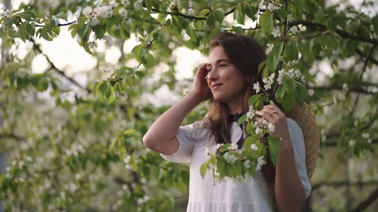 romantic female portrait in blooming garden in spring day happy and inspired woman in white dress