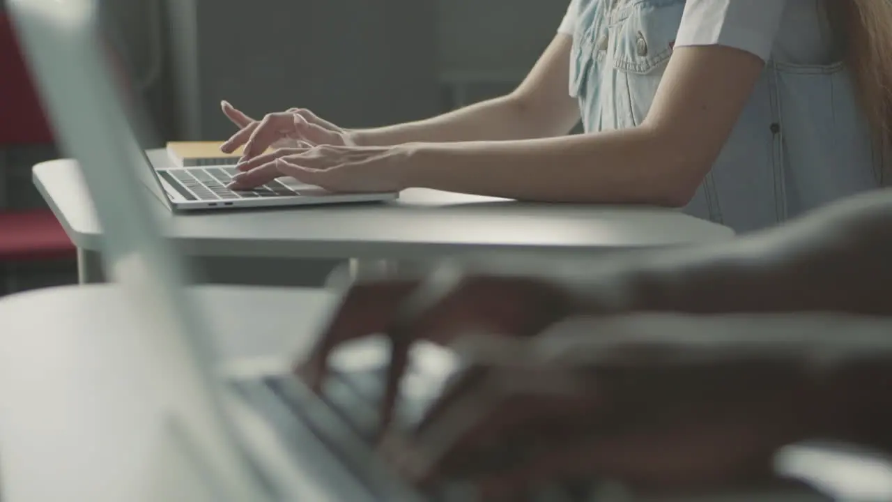 Students' Hands Typing On Laptops