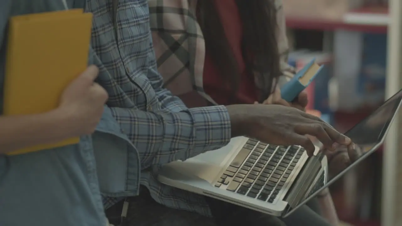 Multicultural Students' Hands Working With A Laptop