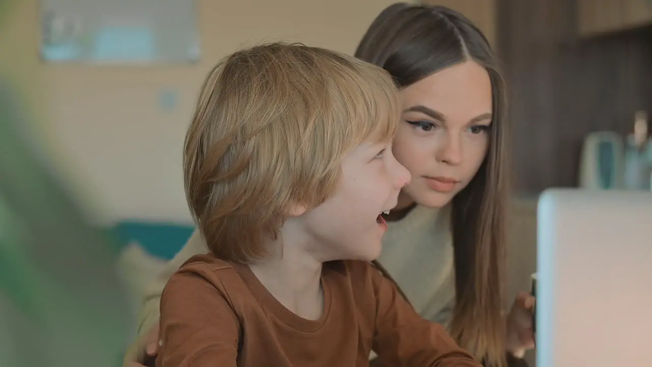 Little Boy And Older Sister Watching Laptop At Home