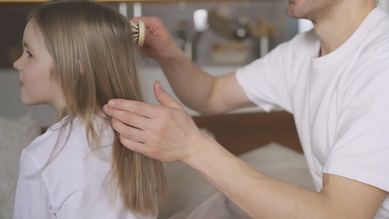 Dad Combing His Little Daughter's Hair At Home 1