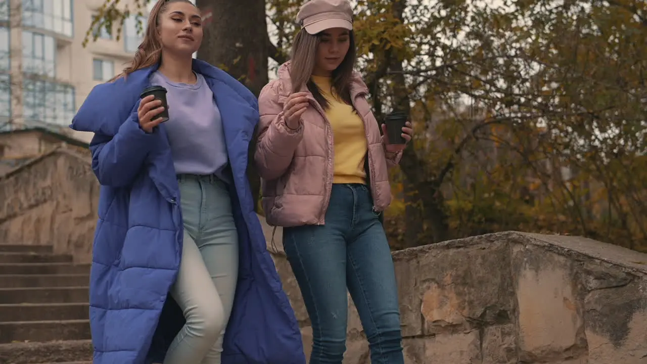 Female Friends Talking And Laughing While Walking Down The Street 1