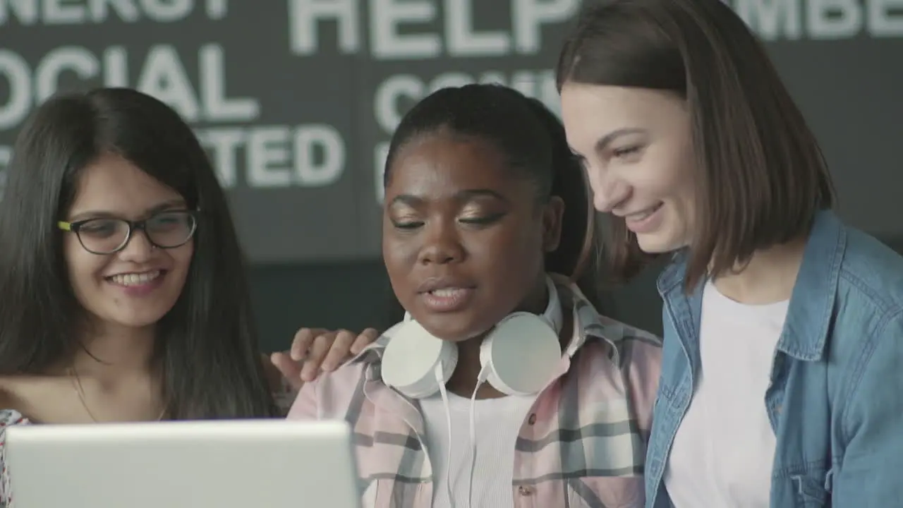 Multicultural Group Of Student Girls Laughing In Front Of A Laptop