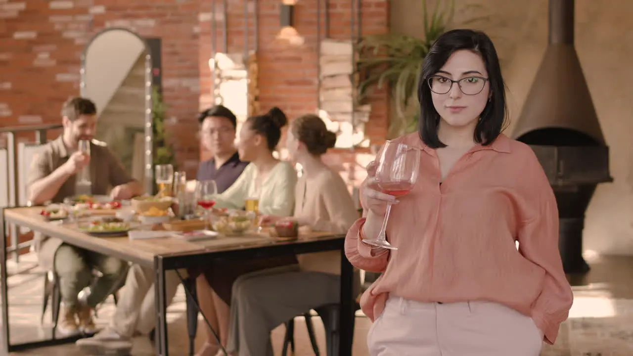 A Young Woman Drinking Wine At A Dinner Party