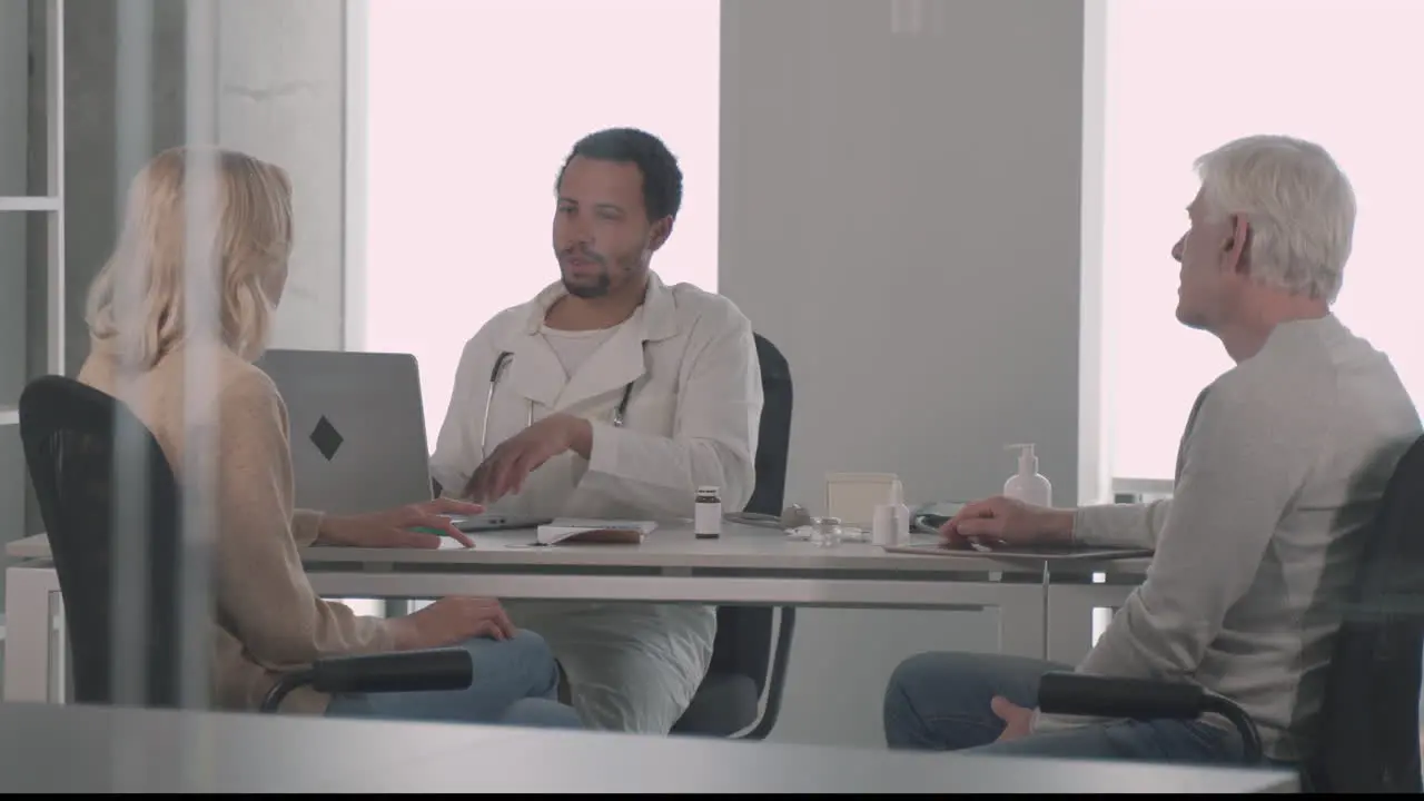 A Young Black Doctor In A Medical Consultation With A Ederly Couple 5