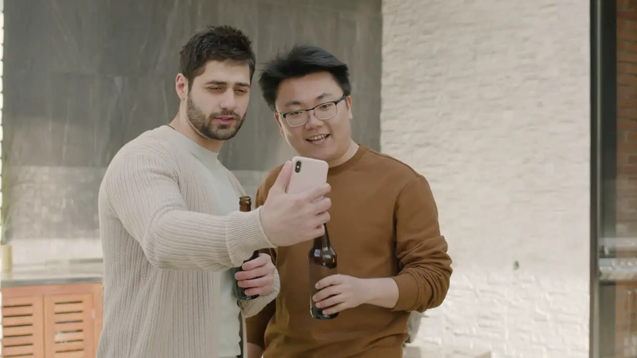 A Young Guy And His Friend Take A Selfie While Drinking Beers