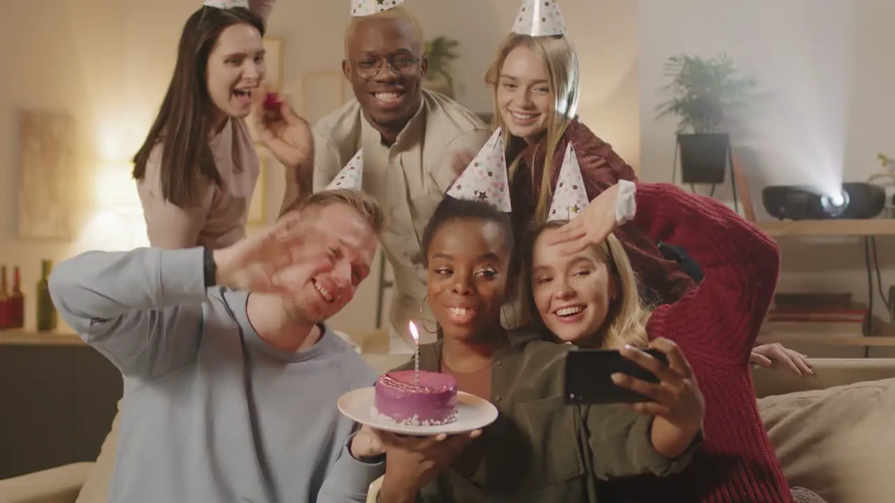 Group Of Friends In Birthday Party Holding A Cake With Candles