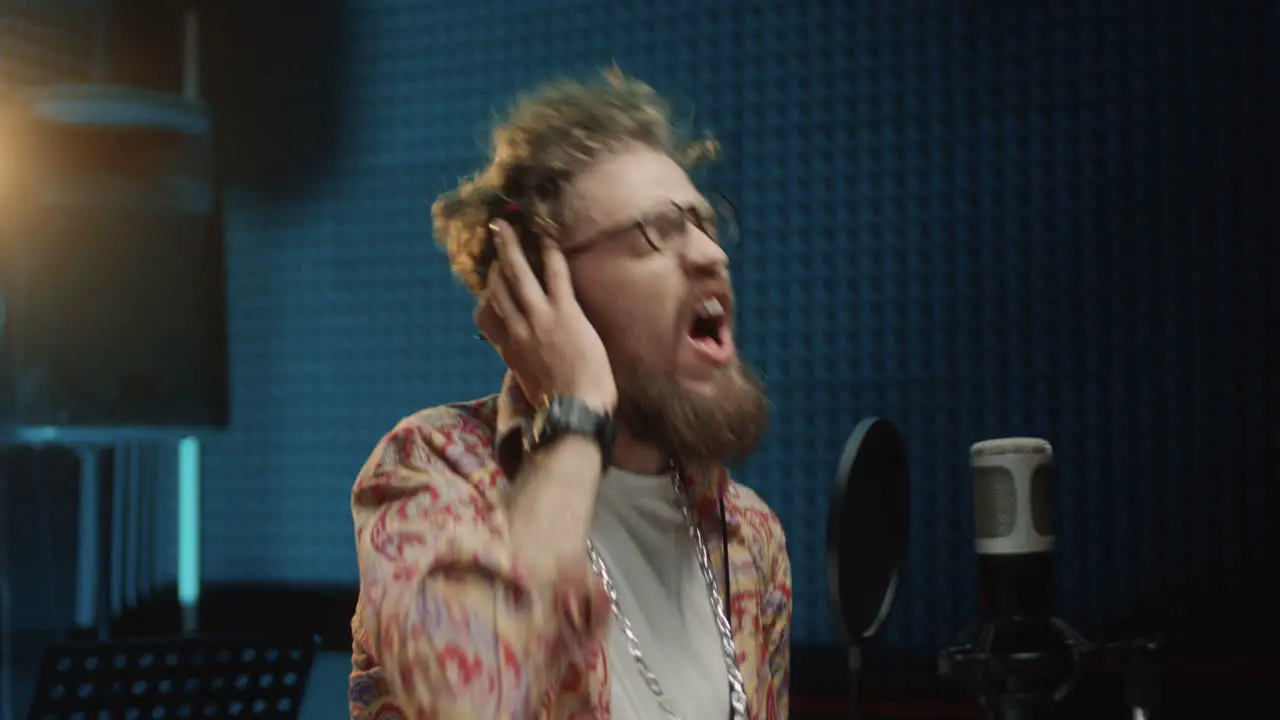 Close Up Of The Emotional Passionate Young Stylish Guy Singing In The Studio Mic And Recording A Song