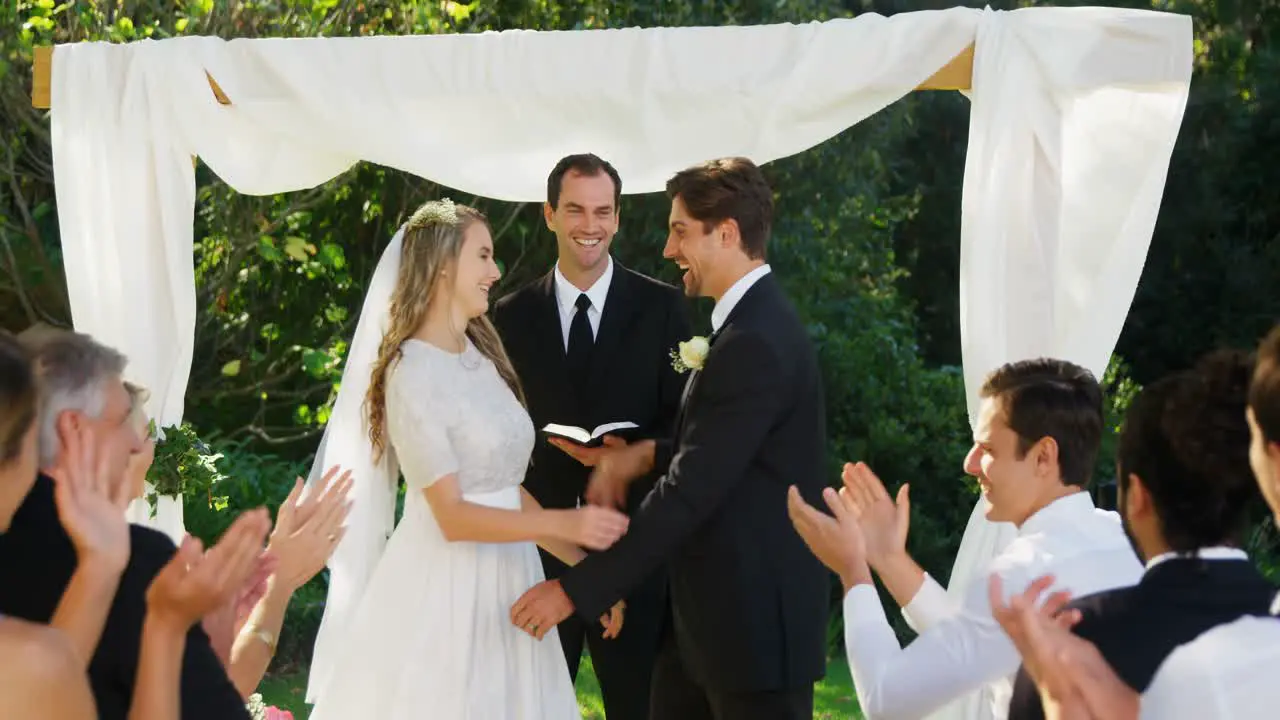 Happy groom showing off wedding ring and happily kissing hugging bride 4K 4k